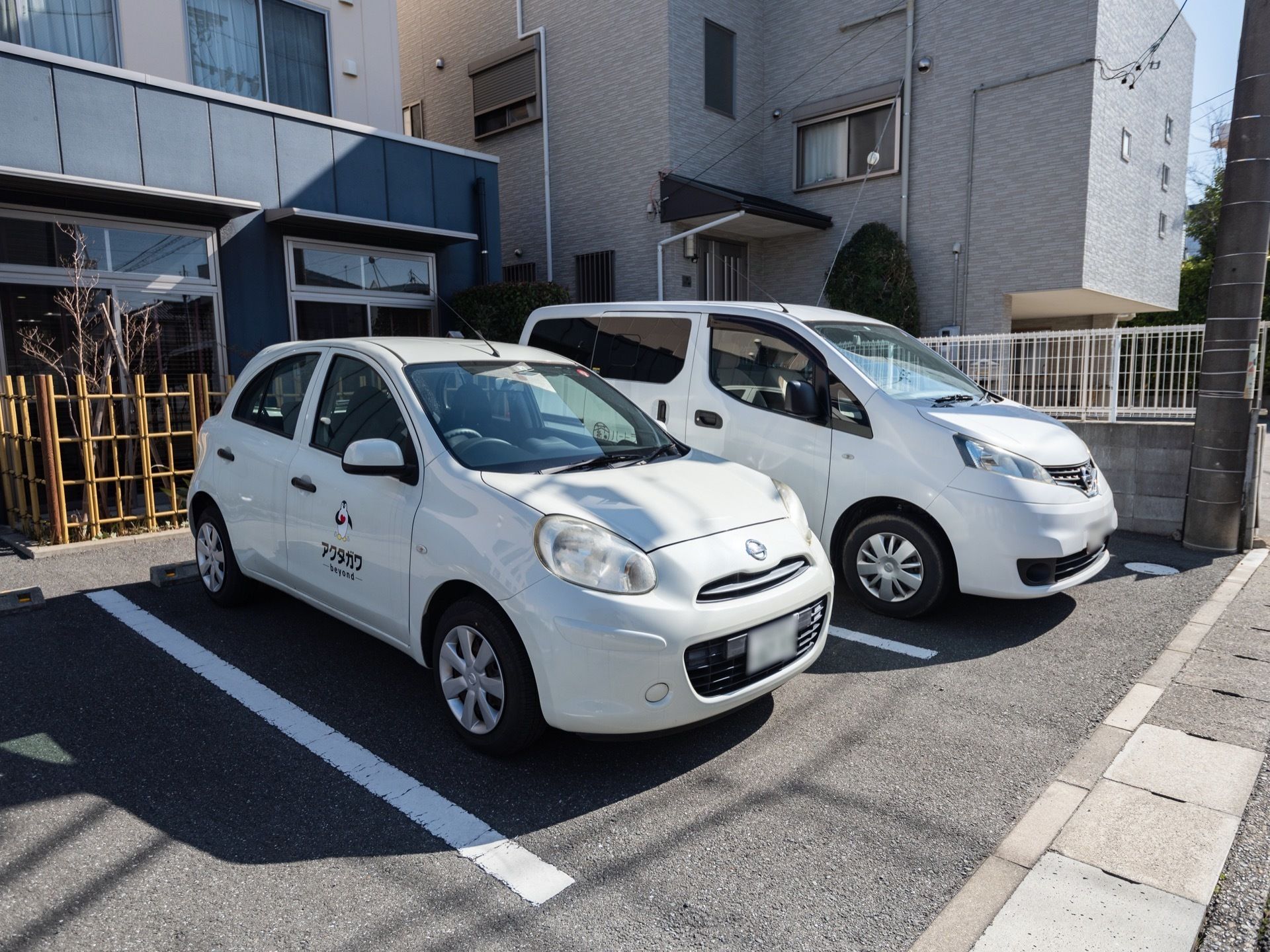 建物の外観は、白色と紺色となっている。駐車場があり、1台ずつの間隔が広いので、車を楽々駐車することができる。