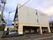 施設の建物は、３階建てで１階がサーモンピンク、２階から上がグレーの壁面になっている。玄関扉前には、左右の脇に駐車場を設けている。