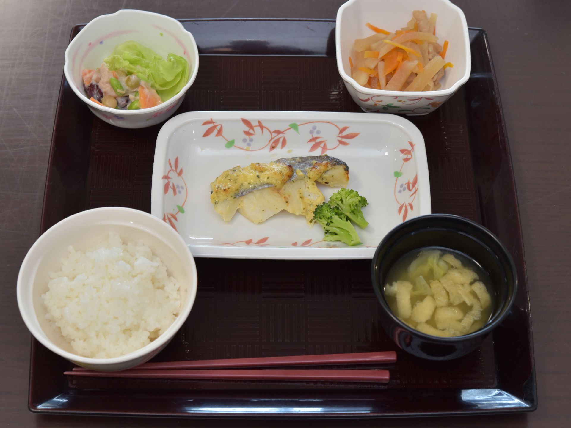 一汁三菜のバランスの取れた食事メニュー。ご飯と汁物、主菜１つ副菜２つが綺麗に盛り付けられており、食材も食べやすい大きさに切られている。