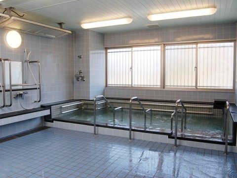 ケアポート梅美台の大浴場。転倒防止の手すりや、専用床材を使用し介助器具も充実させた安心の浴室環境。