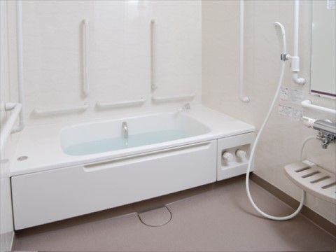 ケアポート梅美台の浴室。手すりや転倒防止の専用床材、緊急時のナースコールを設置した安心の浴室環境となっております。