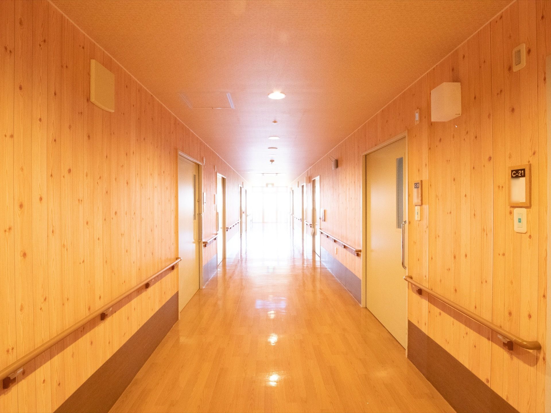 通路は壁や床に木の素材が使われており、あたたかみのある雰囲気である。両側の壁には手すりが取りつけられている。
