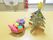 靴箱の上にはかわいらしい置物が二つ置いてある。一つは段ボールで作られたクリスマスツリーで、もう一つはぶどうや柿などの作品である。