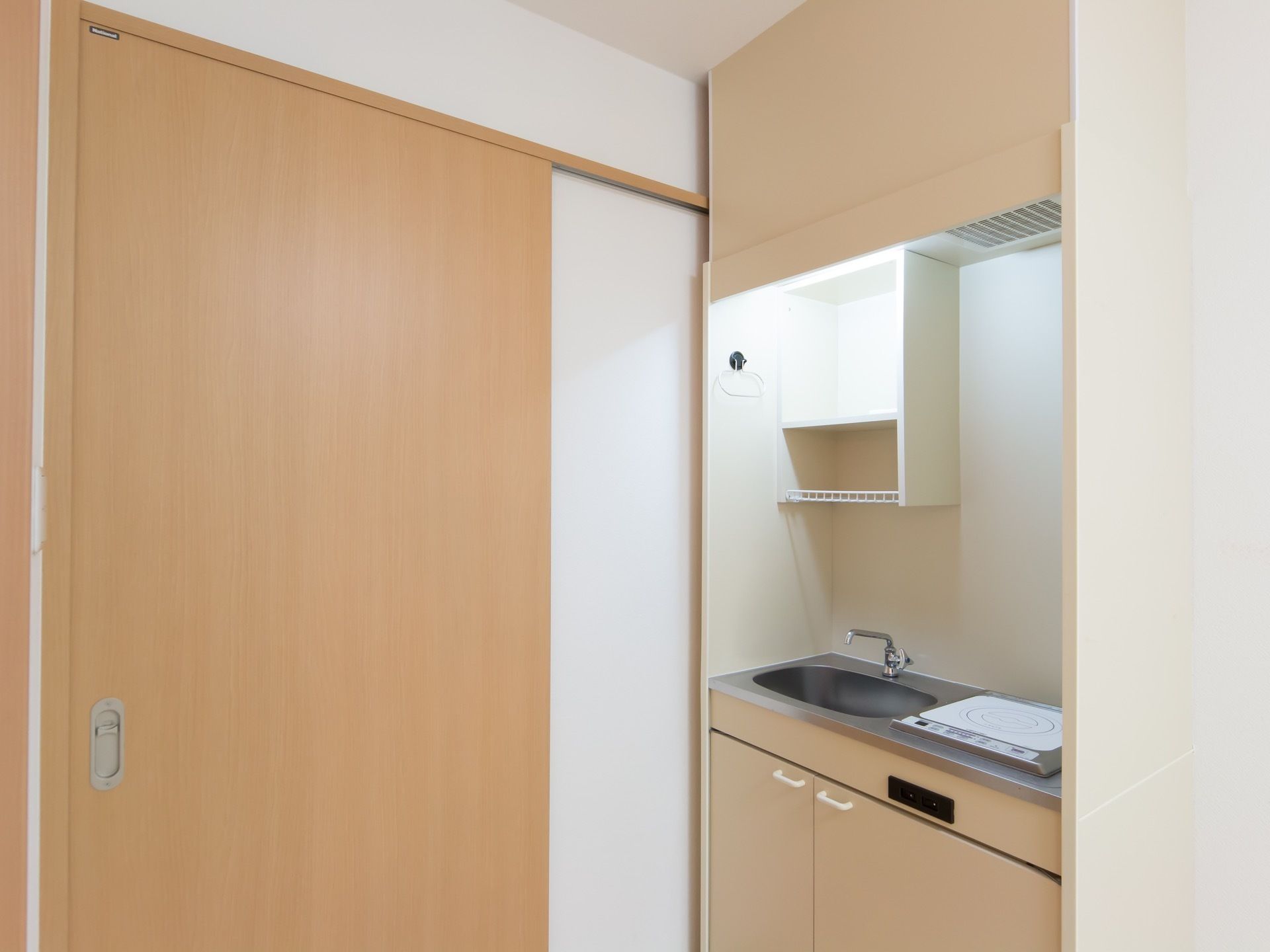 居室の玄関ドア付近の様子。全ての部屋にはミニキッチンが設置されており、ちょっとした料理にも対応できるようになっている。