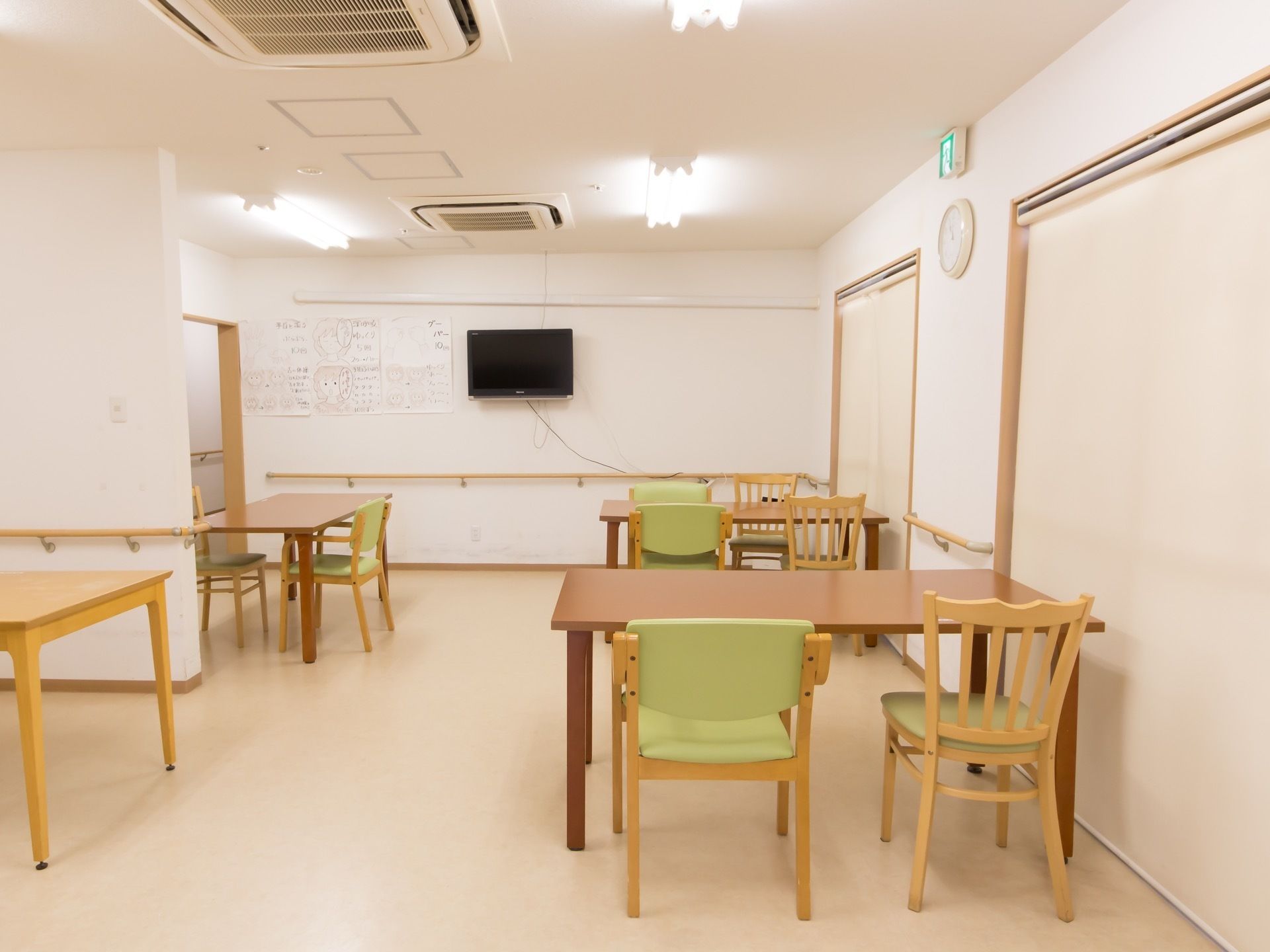 食堂の壁には手すりを取り付けてある。天井には蛍光灯のほかに、埋め込み式のエアコンやスプリンクラーが設置されている。