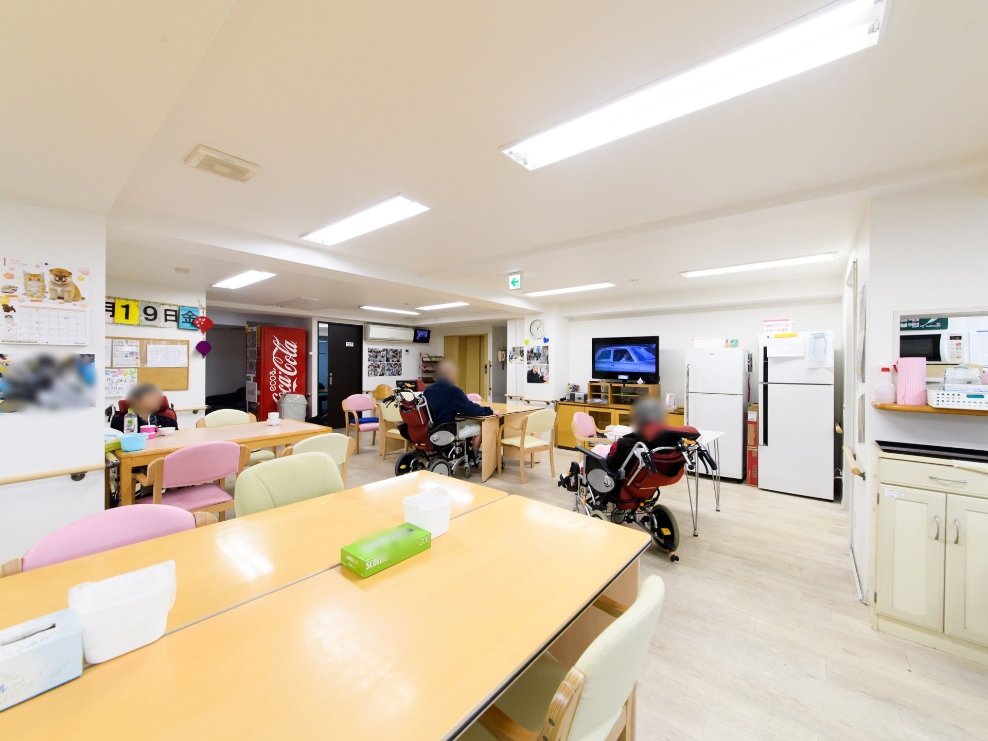 テレビ、冷蔵庫、自動販売機、電子レンジがある。全体的に白を基調としていて明るい空間である。掲示物なども充実している。