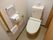 白い壁で、掃除が行き届いたきれいなトイレである。壁には手すりがあるので安心して利用することができる。
