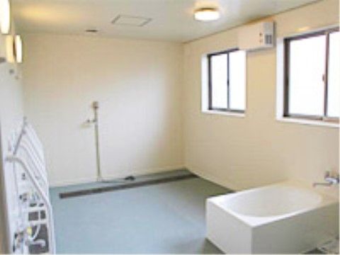 「二ツ山安寿」のデイサービス浴室。シャワーチェアから立ち上がりやすいよう、鏡横に介助の手すりを設置している。