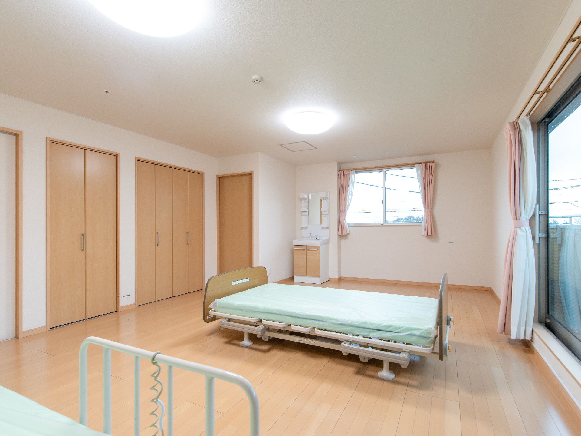 広々とした2人部屋には、ベッドを二つ置いても狭さを感じさせないスペースが確保されている。大きな窓や大きな収納も用意されている。