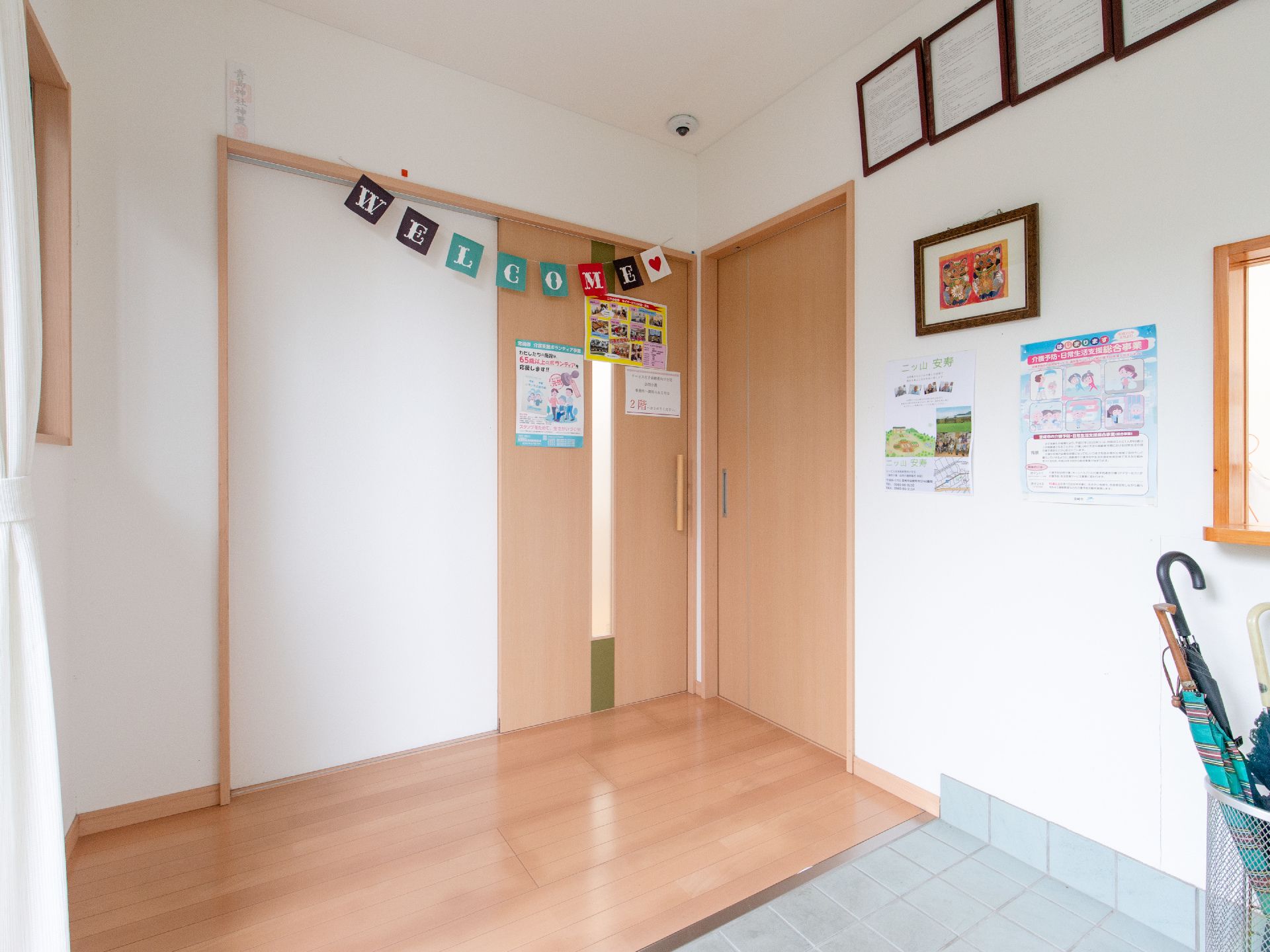 玄関扉の内側にもう一つ扉があるので、入居者様のプライバシーや快適な環境が守られている。玄関にはWELCOMEの飾りつけが施されている。