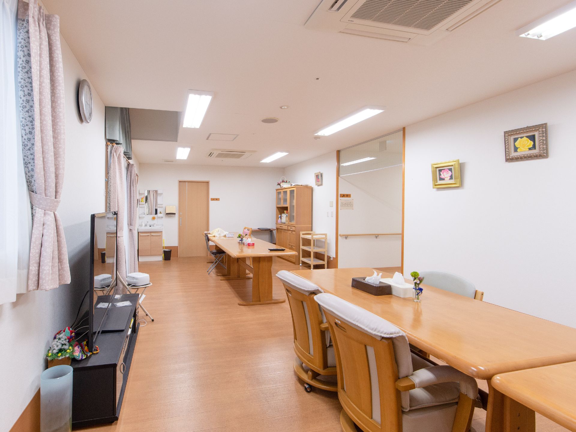 入居者様が集まり、お食事を召し上がる食堂スペースである。室内には洗面台があり、大型テレビが置かれている。