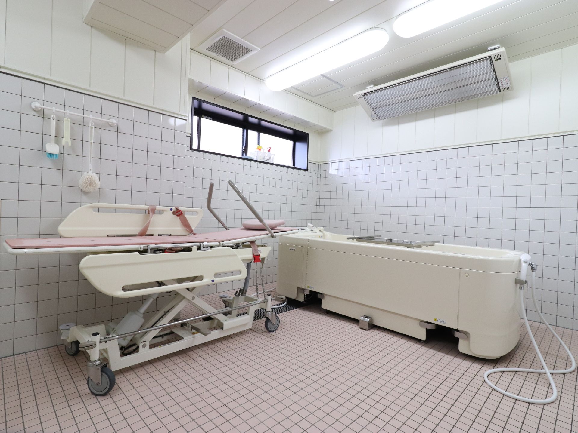 広い浴室には寝たままの入浴を可能とするストレッチャーと浴槽が設置され、天井にはパネルヒーターを設置。冬季でも温かく利用できる。