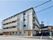 「コンフォートフォレスタ新柴又」の外観。駅から近く、ベージュの外色を施した4階建てのマンション風な外観。