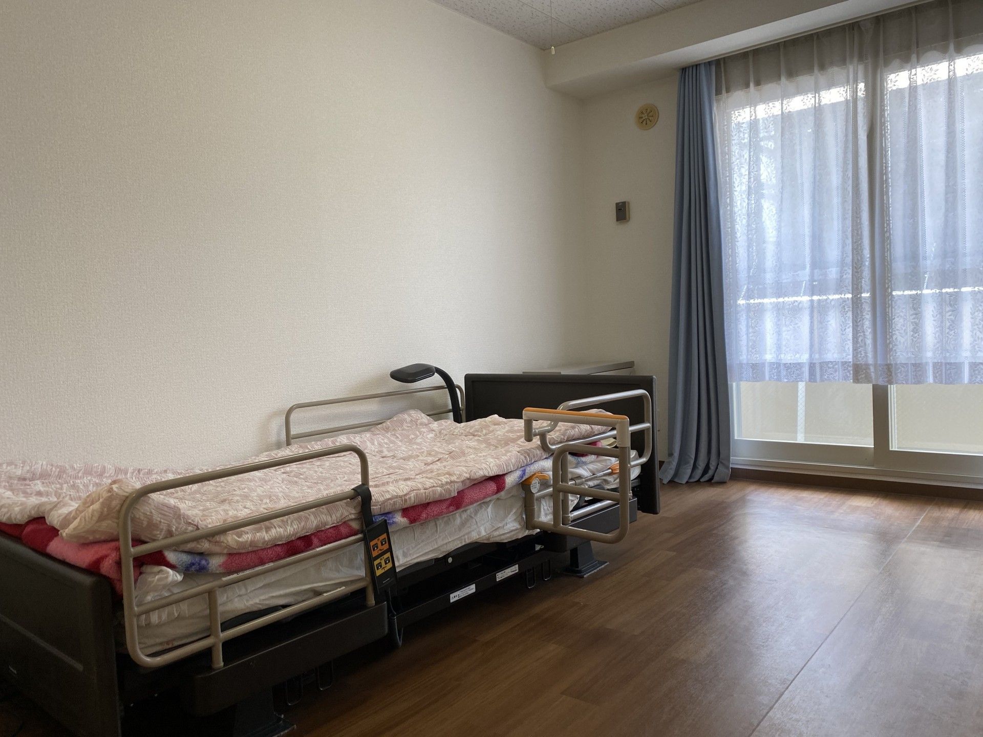 拳を突き出しリハビリをする高齢女性と指導をする理学療法士の男性