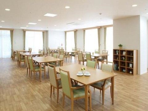 ４つの椅子がテーブルとセットになっており、間隔を空けて配置されている。手前のテーブルには、ソーサーに載せられたコーヒーカップが２つある。