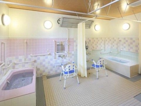 広い浴室で、左右の壁に沿って浴槽が１つずつ設置されている。中央部分にカーテンがあり、それを引くことで仕切り代わりにできる。