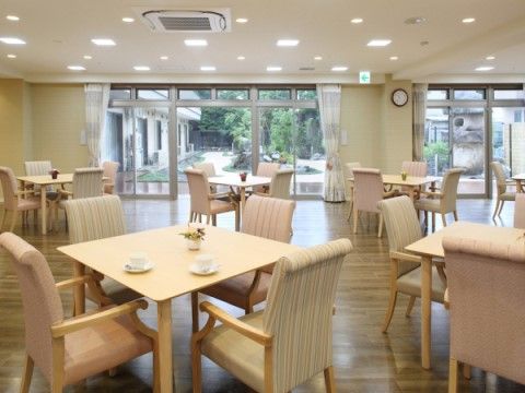 大きな窓から中庭を見渡すことができるダイニングである。室内には４人掛けのダイニングテーブルが並んでいる。