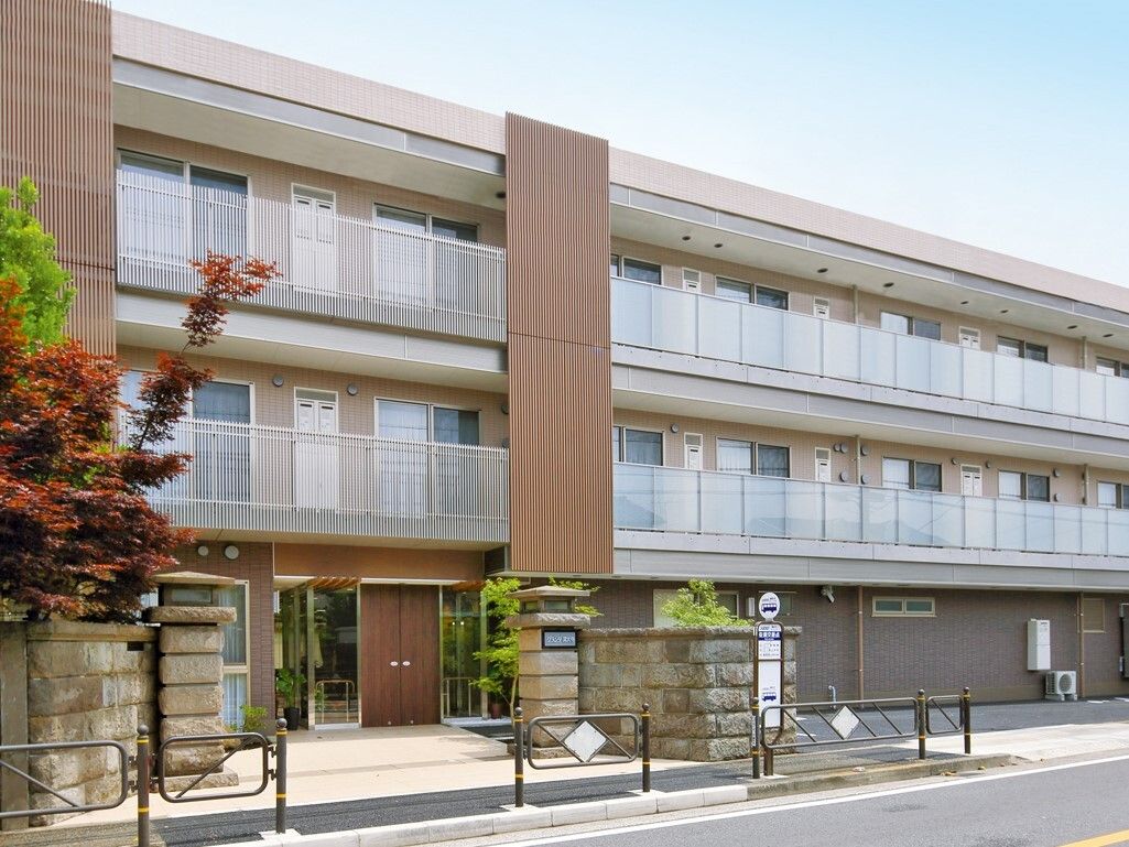 ３階建てのマンションのような外観の施設である。敷地内には大小さまざまな植栽を設けている。施設前にはバス停がある。