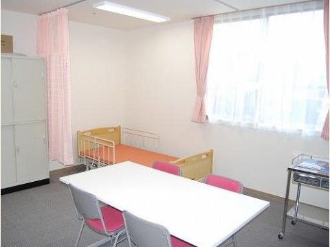 奥にベッドが設置されていて、その手前に仕切り用のカーテンが設置されている医務室