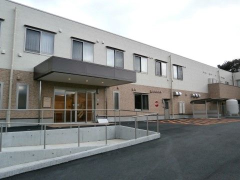 手前に手すり付きのスロープが完備されている、二階建て施設の外観