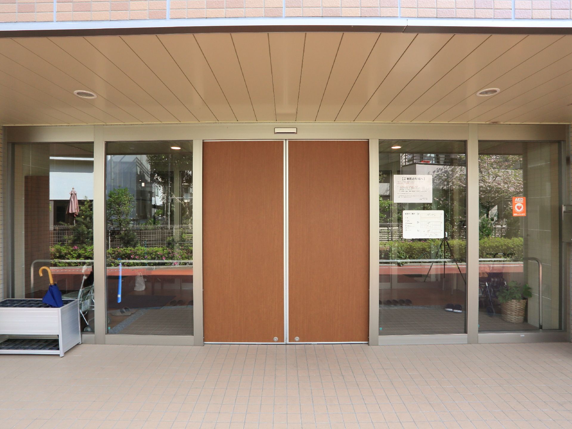 車いすの方が通りやすいように、大きな自動ドアが入り口に設置されている。また、外には傘立てが置かれている。