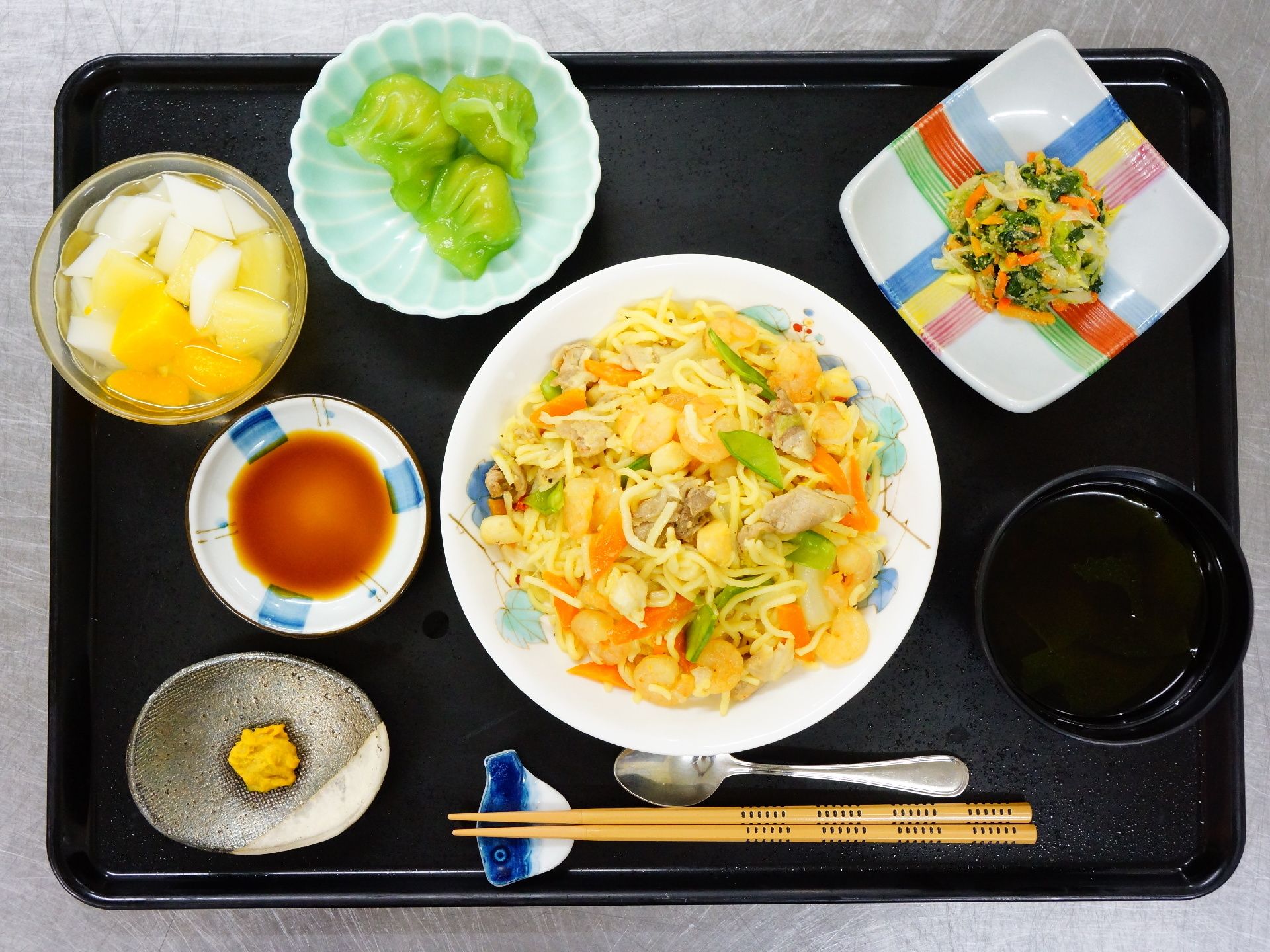 海鮮焼きそば、水餃子3つ、野菜の和え物、ミカンやパイナップルの缶詰が食事メニューとして提供される日がある。