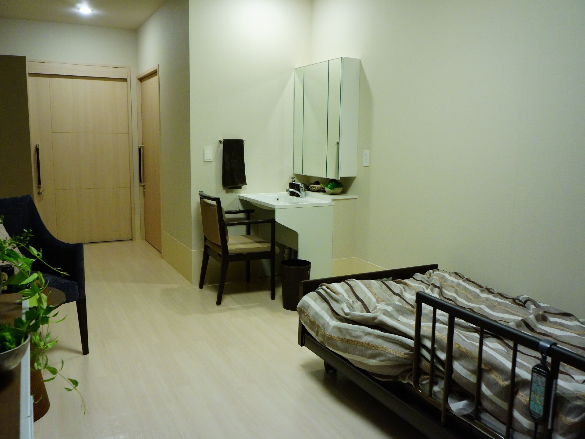 部屋にはベッドと観葉植物が置かれている。部屋の一角は洗面スペースになっていて、椅子もあるのでゆっくりと身支度ができる。