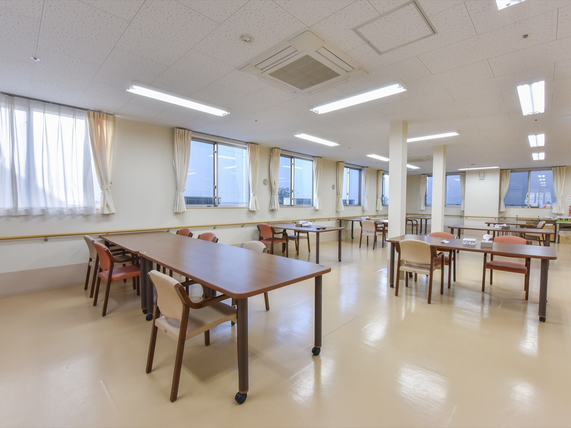 食堂の壁面には等間隔に窓が複数並んでおり、明るい空間である。４人がけテーブルにはキャスターが付いているので、移動させることが可能だ。
