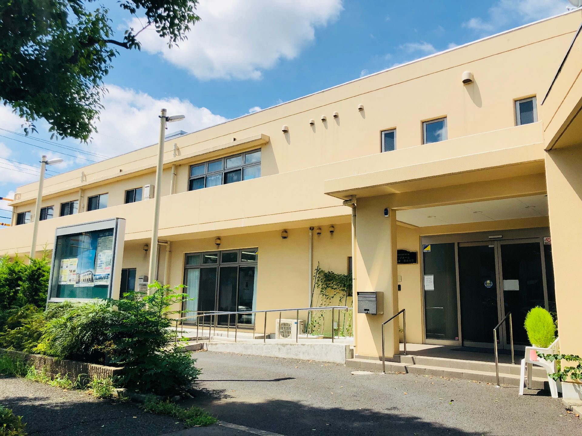 施設外観の、エントランスの様子である。段差の低い階段や、傾斜の緩やかなスロープには手すりがついている。