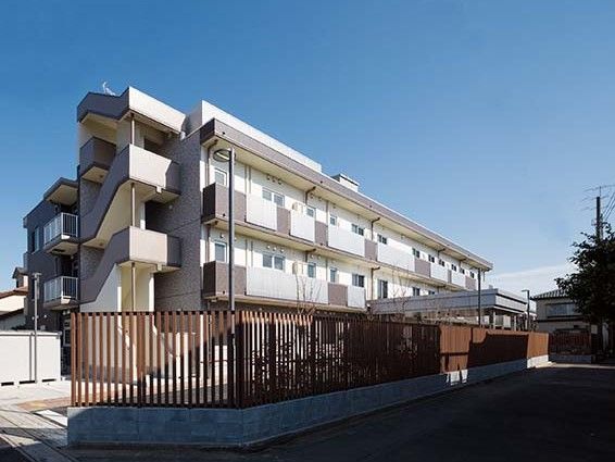 施設は白と茶色を基調とした３階建てで、横長のアパート風の建物である。外階段があり、周囲には茶色のフェンスがある。