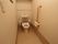 居室前の廊下沿いに、トイレが複数箇所設置してある。ベージュ系で落ち着いた印象のトイレには、手すりと背当てがあり、姿勢が保ちやすい。