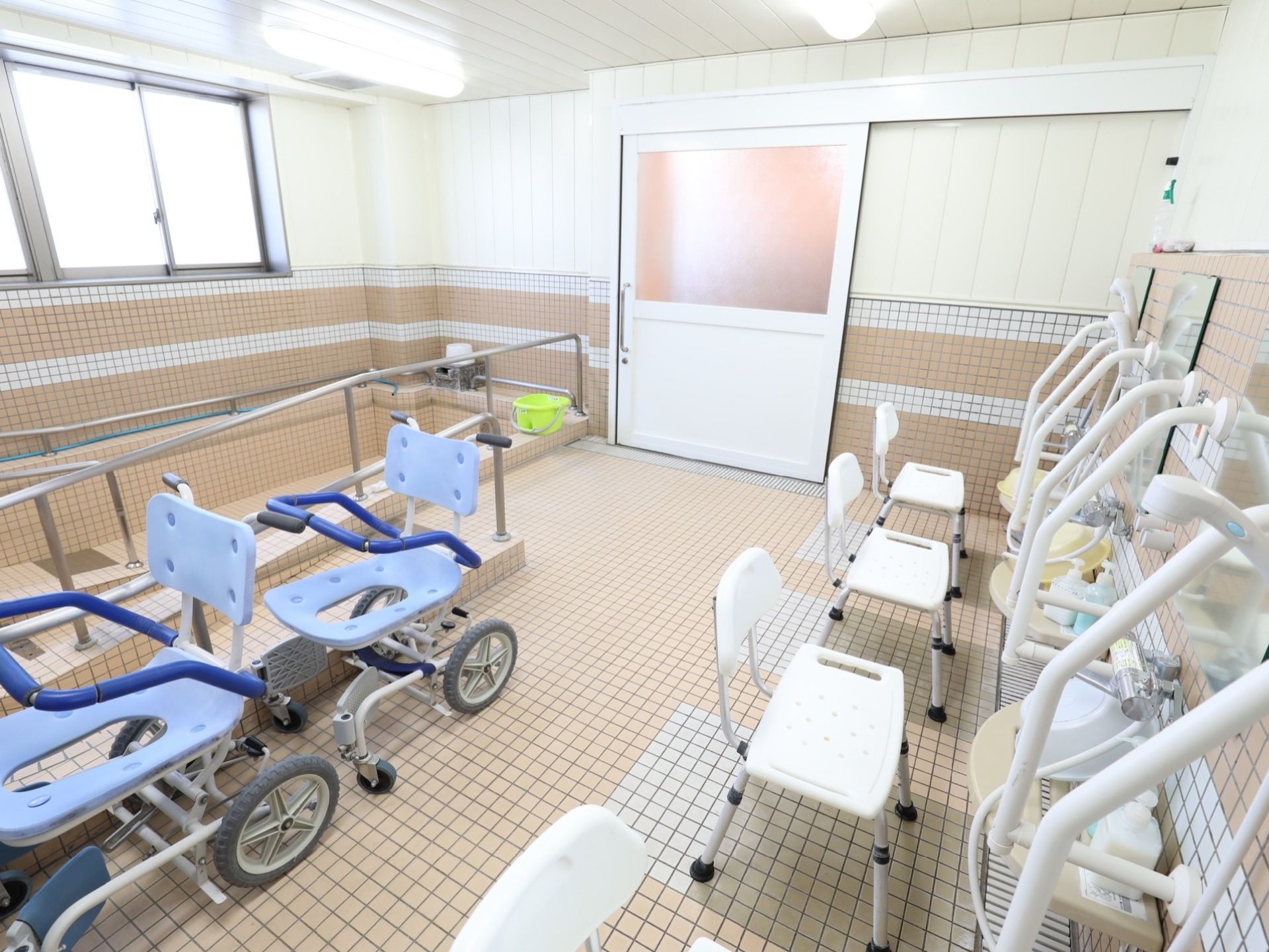 浴室は広く、窓から光が入り明るい。出入り口はスライド式の扉になっており、安全に開閉ができる。洗い場には手すりがあり安全である。