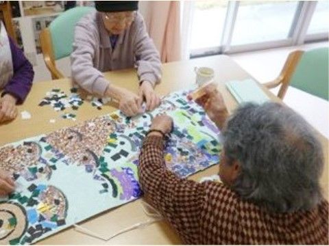 シックな色合いの折り紙を使い、ちぎり絵を楽しんでいる入居者様たち
