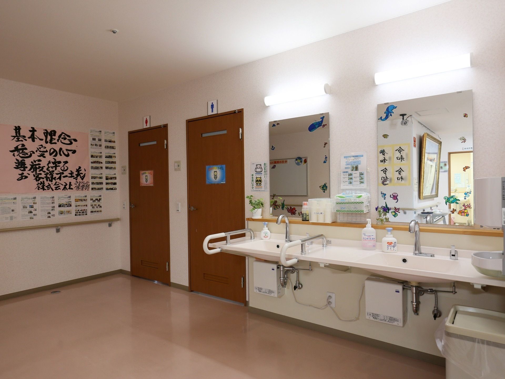 男性用と女性用のトイレの入口があり、その右側に、洗面台が２つ並んで設置されている。ハンドソープのボトルが置かれている。