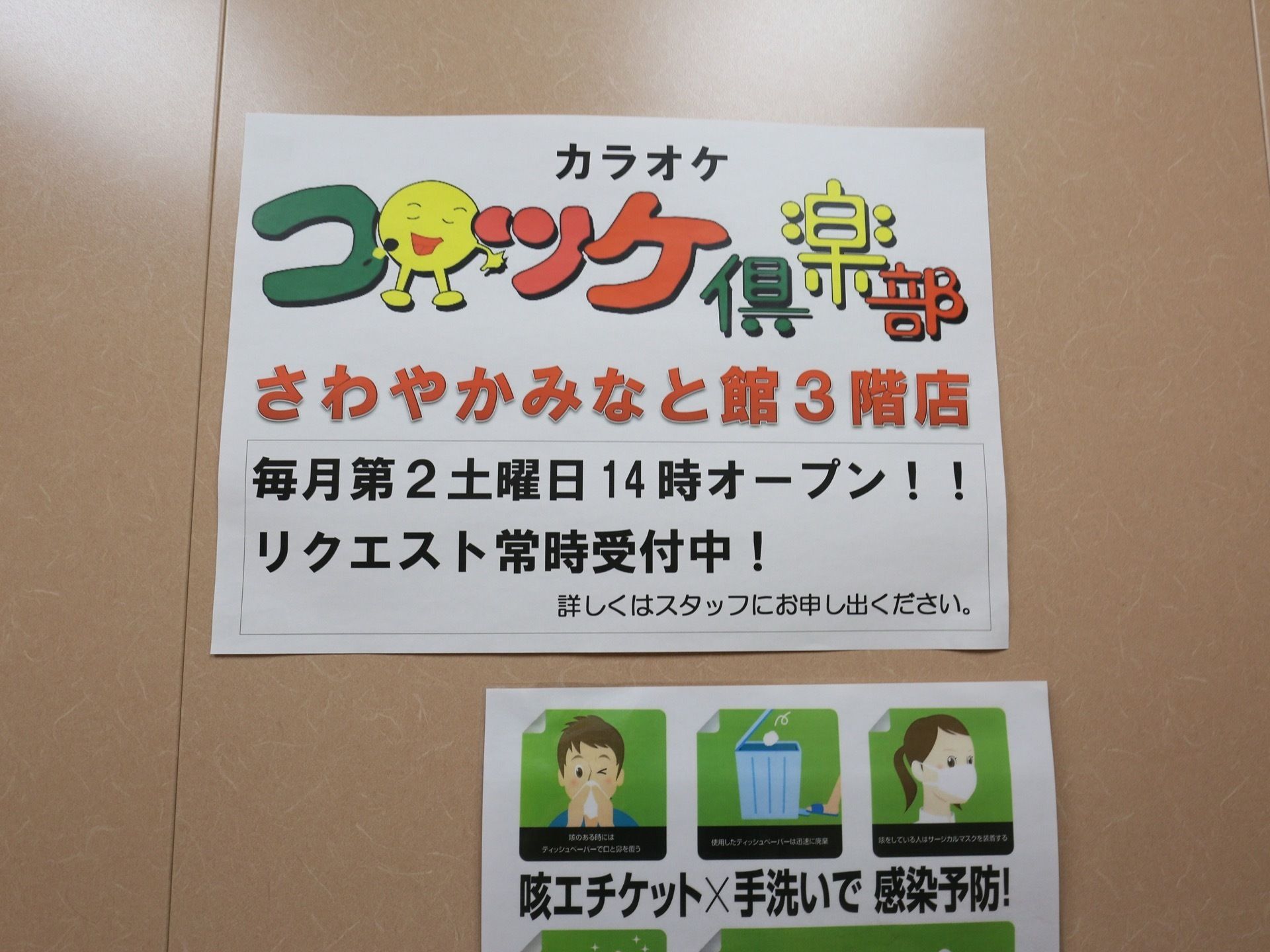 カラオケの定期開催の案内が貼られている。施設の３階で月一回開催されている。感染予防のポスターもある。