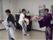 複数の踊り手が鮮やかな紫や市松模様の着物をまとっている。きらびやかな扇子を手に舞を披露し、入居者様の目を楽しませている。