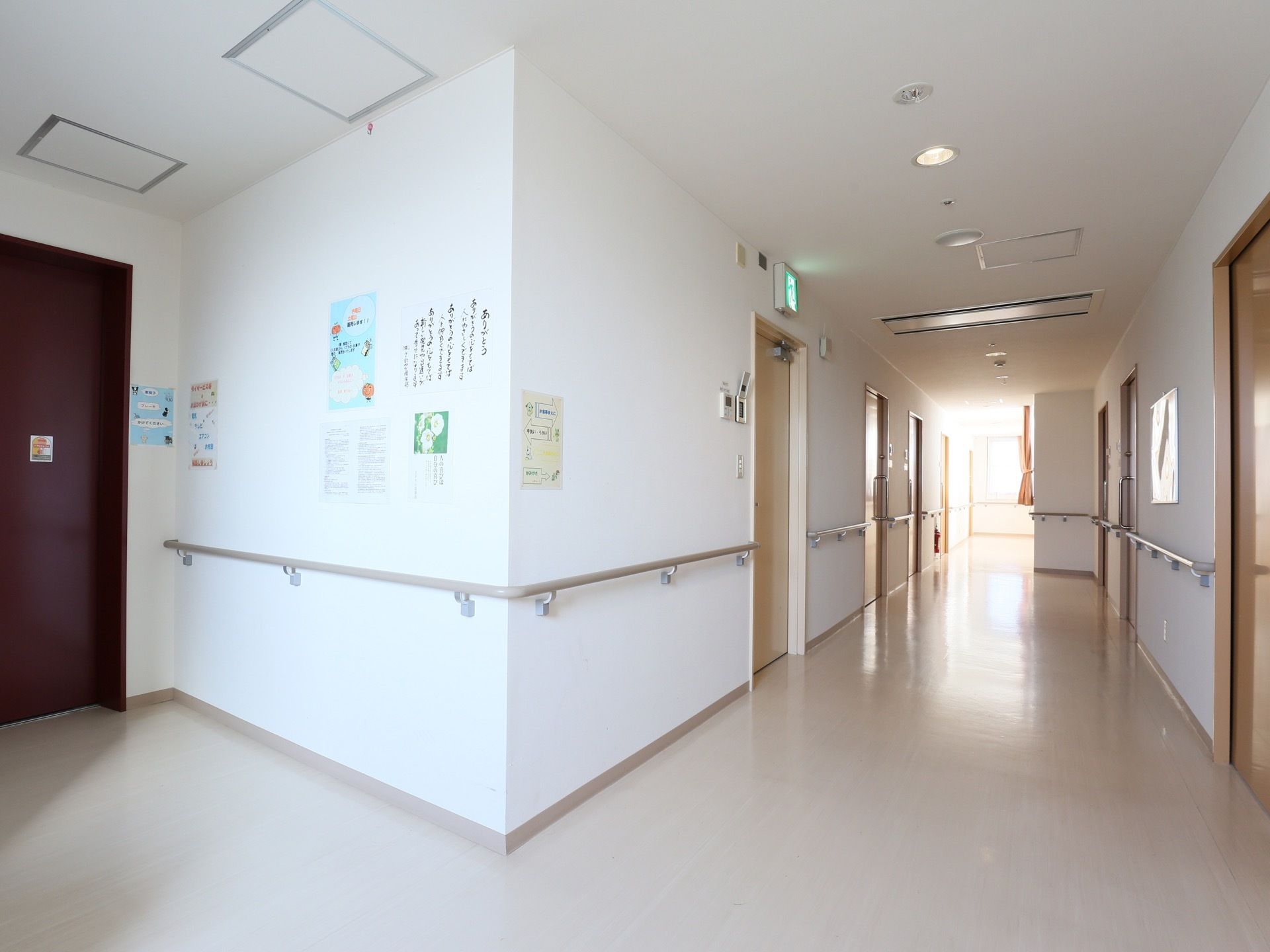 白い壁紙で明るく清潔感のある廊下には、左右の壁に手すりを設置して入居者様が掴まって安全に通行できるようにしている。