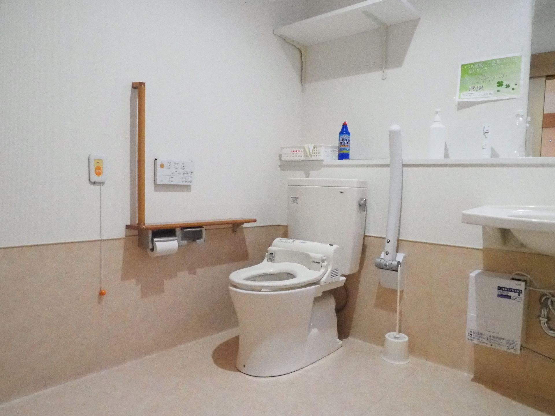 トイレ洗面スペースは白とベージュ色でまとめられたデザインで、広々とした空間になっている。緊急ボタンも付いていて安心である。