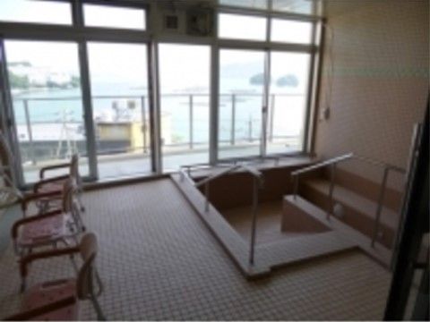 窓からオーシャンビューの風景を楽しみながら、ゆったりとご入浴いただける浴室。湯船には、手すり、スロープが完備されている。