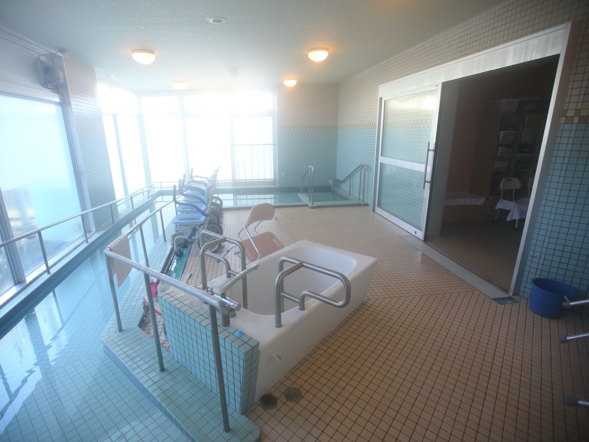 窓に沿って細長い浴槽があり、多くの人が入浴することが可能である。中央部分には、3台のシャワーキャリーが置いてある。