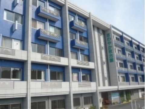 白と青に塗られた、清潔感を感じる外観となっている。２階から５階にかけて大きく施設名が表示されている。