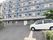 建物のすぐ前は駐車スペースとなっている。草木の横に2台の車が置いてある。きちんとアスファルト舗装されていて安全面にも配慮がある。