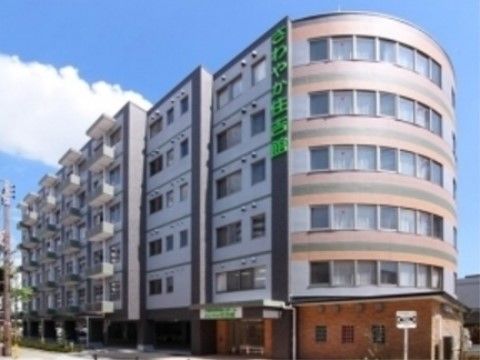 側面はラウンドしたデザインの鉄筋コンクリート６階建ての建物である。ラウンドした壁面の端には緑色の大きな文字で施設名が入っている。
