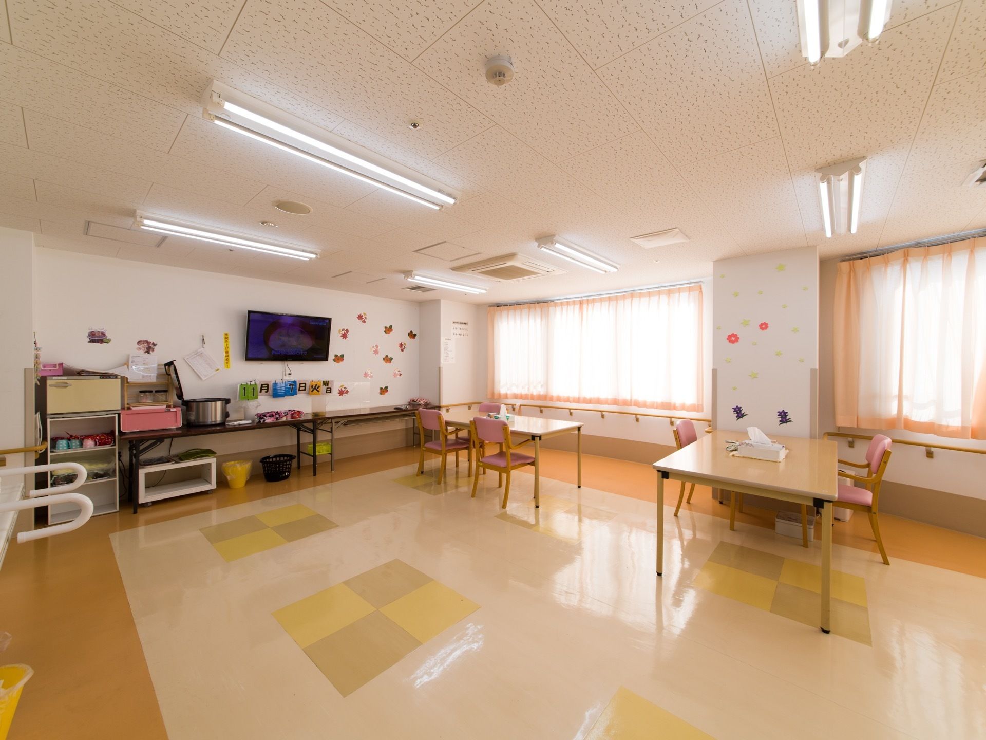 食堂、機能訓練室として使う部屋なので明るく広く、行動がスムーズにできる。壁面には手すりが取り付けてあり、歩行をサポートしてくれている。