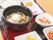 真ん中に置いてある大きなお椀に、キノコうどんが入っている。うどんの上には、温泉卵と蒲鉾、青ネギなどが盛り付けられている。