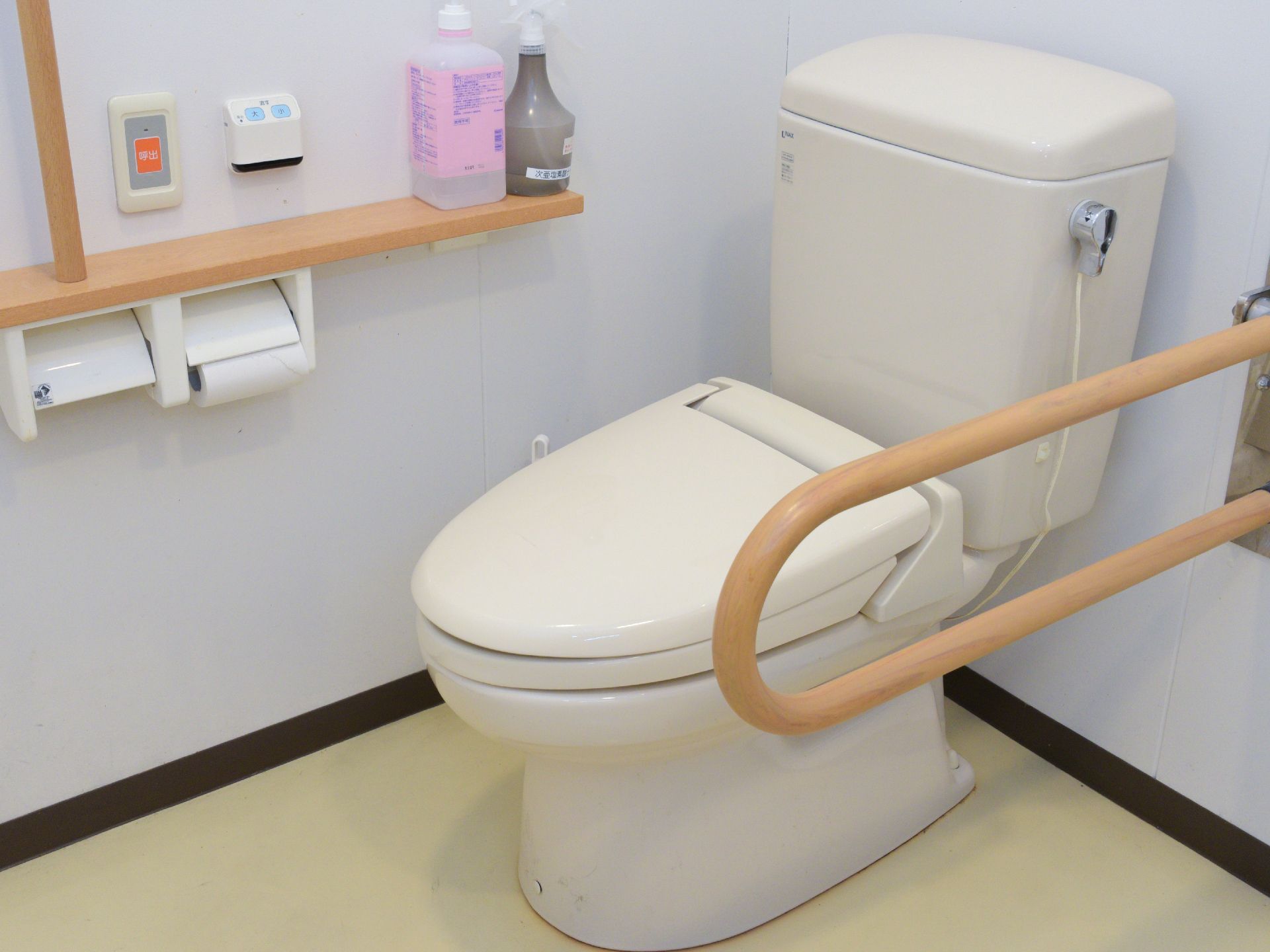 トイレは、白でまとめられたデザインである。トイレのすぐ横には、ベージュ色の手すりが付いている。丁寧に掃除されていて清潔である。