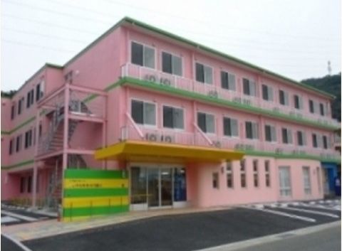 ３階建てのピンクの建物である。エントランスは間口の広い自動ドアで、目の前には駐車スペースが完備されている。