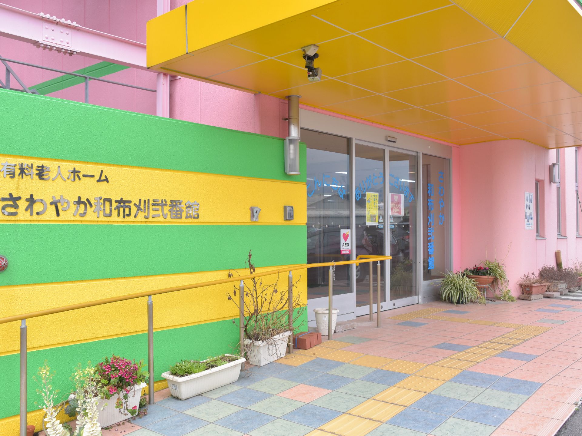緩やかなスロープになっているので、足が不自由な方や車椅子でも出入りしやすい。建物がカラフルな色遣いである。