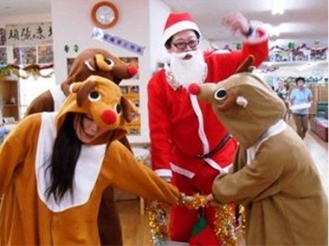 天井には輪飾りがかけられている。その部屋にはサンタクロースやトナカイの着ぐるみを着た４人のスタッフが立っている。