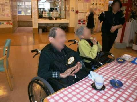 車椅子でテーブルについて、ティータイムを楽しんでいる2名の入居者様
